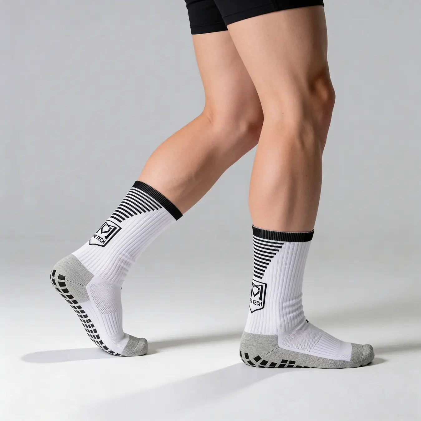 Footballeur portant des chaussettes antidérapantes grip sous ses chaussettes de match